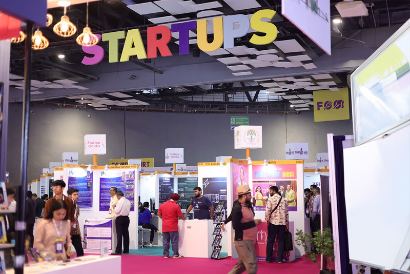 A modern multi-story building with balconies and a street view with people walking.